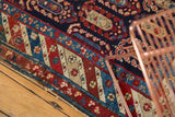 Geometric border of the antique Caucasian runner with red, sky blue, and sand tones.