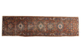 Wide vintage Heriz runner with column geometric medallions, dusty brick red, navy, and mallard green.