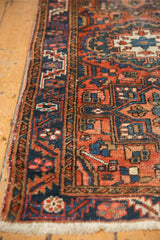 Vintage Heriz runner close-up: serrated leaf border in dusty brick red, navy, ivory, with mostly even wear.