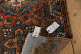 Vintage Heriz runner side, traditional geometric pattern in dusty brick red, navy, ivory, visible wear.