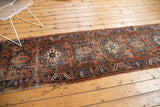 Visible tatter and worn geometric patterns on a Vintage Heriz runner end.