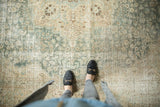 Distressed vintage Tabriz carpet with faded aqua, sand, and beige floral field texture.