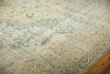 Faded aqua and beige floral motifs with chocolate brown on a distressed vintage Tabriz rug.