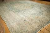 Distressed Tabriz carpet corner, faded aqua and beige floral motifs, scalloped spandrel.