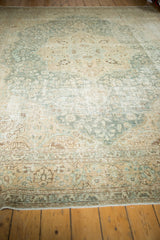Distressed Tabriz carpet, time-softened aqua and beige floral patterns, visible wear.