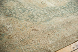 Distressed Persian Tabriz carpet detail: worn aqua, beige floral motifs, visible foundation.