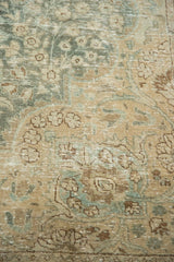 Distressed vintage Tabriz carpet field, delicate aqua green floral patterns, visible foundation.