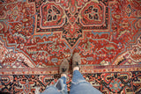 Vintage Heriz rug detail showing central medallion and abrashed cherry-to-brick red field.