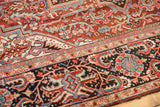 Close-up detail of vintage Heriz rug showing geometric vinery, madder red, navy, and blush.
