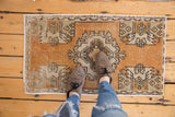 Faded tangerine rust distressed Oushak rug with ivory geometric germinating plant motifs.
