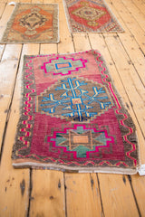 Textured upper field of a distressed vintage Oushak rug, showing pink, blue, grey medallions.