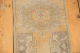 Distressed Oushak rug texture, showing faded beige, pale sea foam green, and oxidized silver motifs.