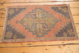 Faded diamond medallion with dark slate silver blue on a distressed Oushak rug.