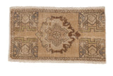 Distressed vintage Turkish Oushak rug mat with roundel medallion, soft beige and brown.