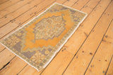 Distressed Oushak rug corner with geometric stepped patterns and alternating floral petals.