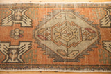 Distressed Oushak rug pile texture with diamond motif in oxidized silver and dark apricot.