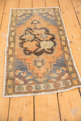 Distressed texture of a vintage Oushak rug, revealing faded terracotta, charcoal, and ink blue.