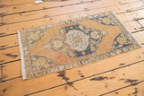 Distressed vintage Oushak rug's corner with faded apricot field and charcoal border.