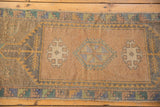 Worn geometric medallion and gul motifs in pale blue, aqua, and sand tones.