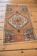 Distressed pile texture, intact side selvage, and short fringe of the Oushak rug mat.