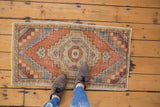 Distressed Oushak rug showcasing a roundel medallion in apricot, ivory, and slate blue.