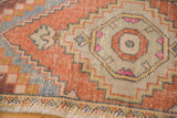 Textured, distressed vintage Oushak rug pile with apricot roundel and ivory, slate blue pattern.