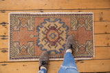 Distressed Oushak rug mat with muted earthy colors and geometric floral roundel.