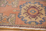 Distressed Oushak rug detail: wine red floral motif, dusty blue, sandlewood field, worn pile.