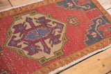 Distressed Oushak rug, brick red field with geometric design, subtle foundation exposure.