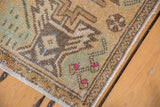 Distressed Oushak rug pile, showing original side selvage and green, blue patterns.