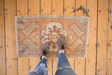 Distressed vintage Oushak rug mat, apricot geometric floral gul medallion.