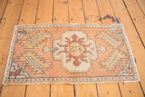 Distressed Oushak rug corner with apricot and sandlewood field, serrated leaves, and geometric border.