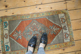 Corner of hand-knotted Oushak rug with burnt orange serrated medallion and ivory border.
