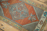 Vintage Oushak rug corner featuring serrated medallion in burnt orange, grey, and turquoise.