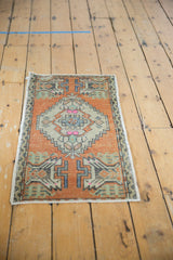 Distressed Oushak rug's lower section with faded burnt orange, ivory, and germinating plant motif.