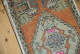 Distressed vintage Oushak rug detail with geometric patterns, faded orange, and pink.