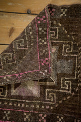 Distressed Oushak rug fold showcasing its rich texture and bright pink geometric motifs.
