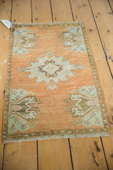 Vintage Oushak rug corner detail, showing distressed terracotta, mint, brown, and visible fringe.