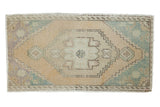 Vintage distressed Oushak rug with oversized medallion, ivory, beige, and pale mint green.