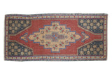 Distressed vintage Oushak rug: stepped diamond medallion, starburst details, cherry red, navy. 1'9