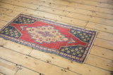 Distressed cherry red field of the Oushak runner, showing geometric starbursts and wear.
