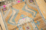 Distressed Oushak rug detail showing wear, serrated leaf pattern, and gold, blue, magenta hues.