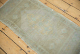 Distressed Oushak rug's subtle beige, pale seafoam pattern with low, even pile texture.