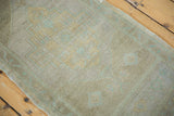 Subtle beige and pale seafoam stepped patterns on a distressed vintage Oushak rug.