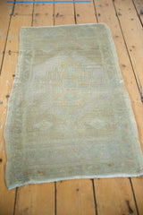 Distressed low pile texture and fringed bottom edge of a pale Oushak rug.
