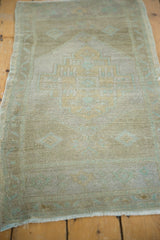 Distressed Oushak rug's low, even pile, beige, seafoam green tones, and bottom fringe.