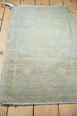Distressed vintage Oushak rug in full view, showing muted beige and seafoam colors.