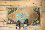 Top-left corner of vintage Oushak rug with chocolate brown field and faded floral blossoms.