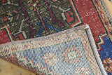 Hand-knotted foundation and secured side of distressed Oushak rug, showing brick red and faded blue pile.