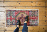 Distressed vintage Oushak rug mat, red and ivory geometric pattern with visible wear underfoot.